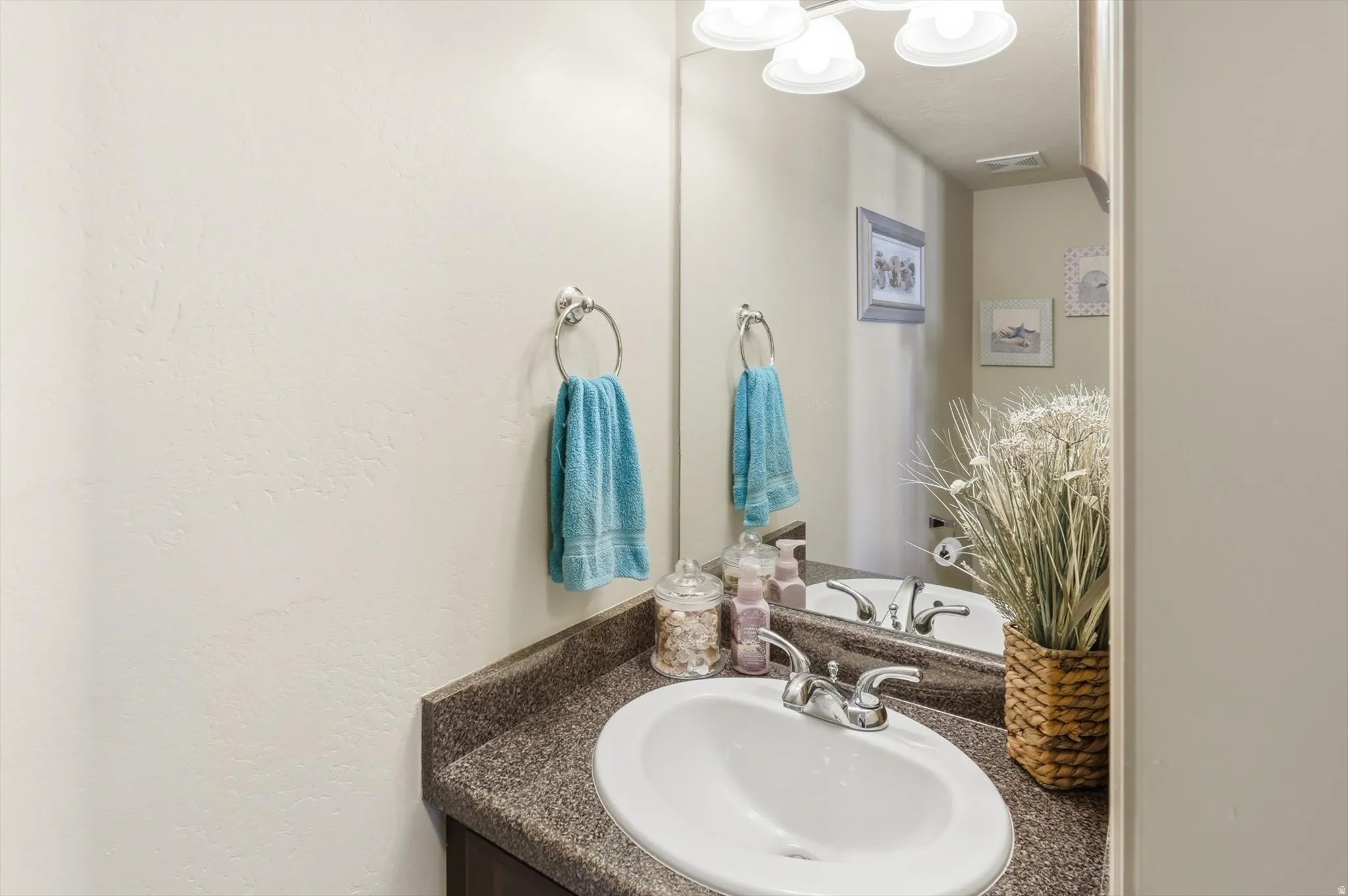 Bathroom vanity featuring an integrated white sink with chrome fixtures