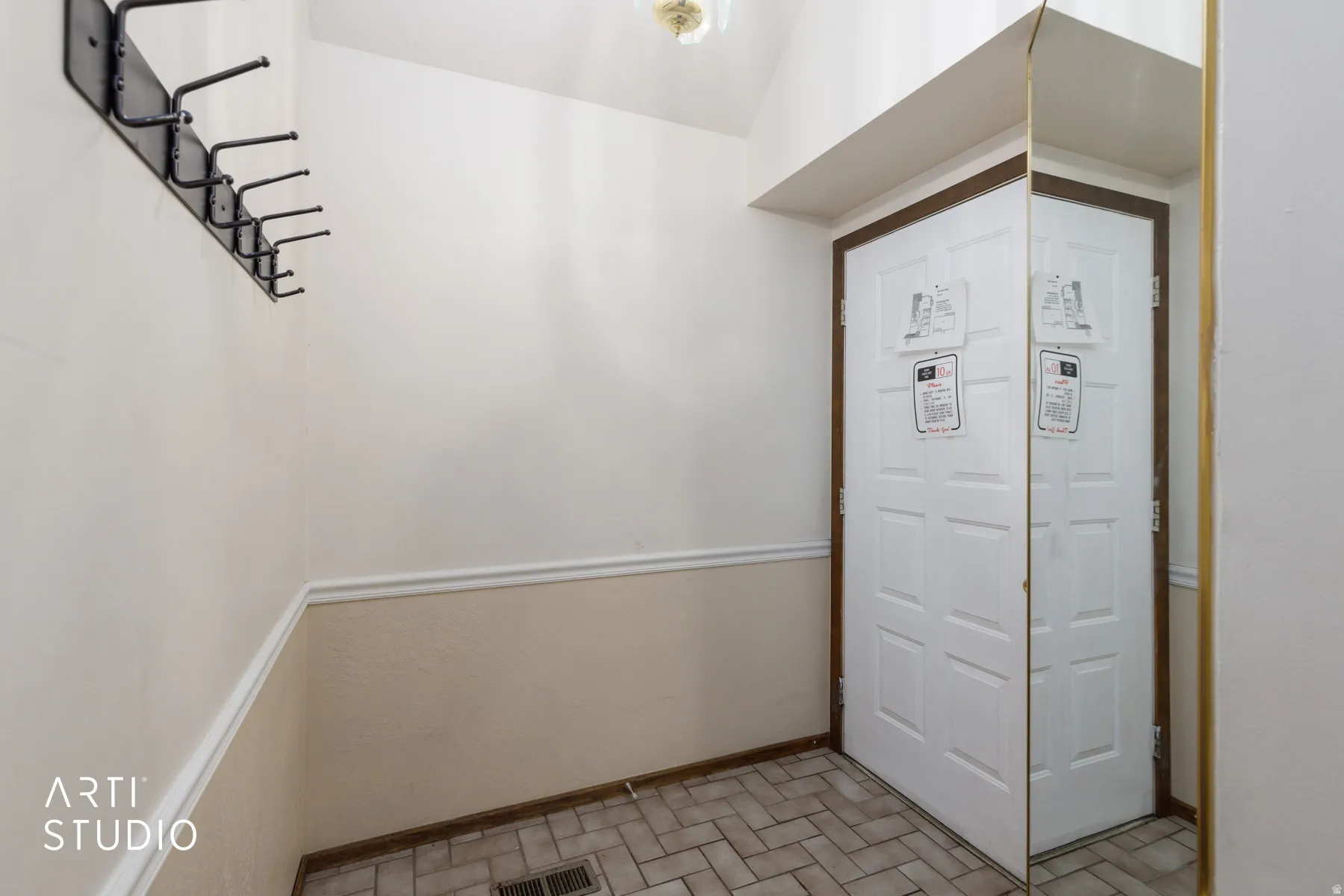 Entryway featuring panel door with decorative trim, full-height mirror, and ceramic tile flooring