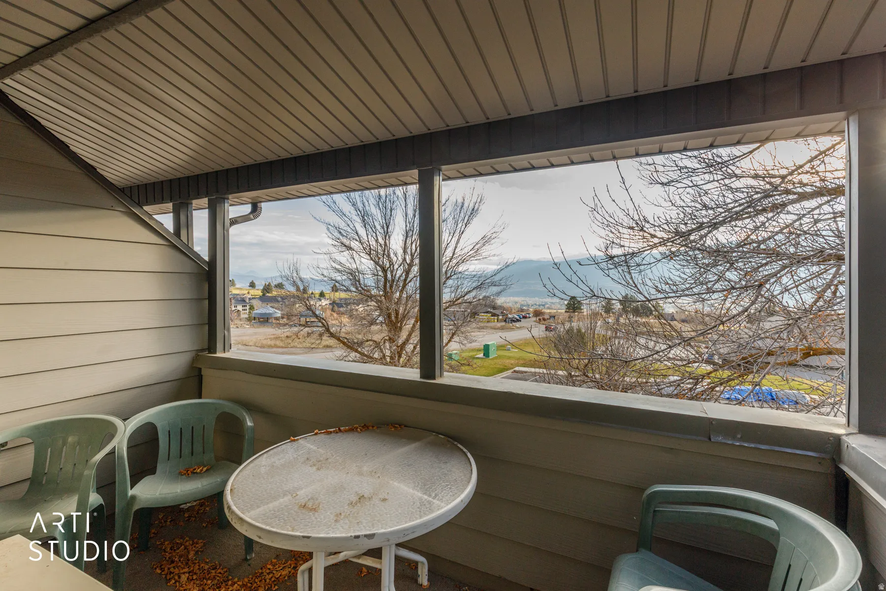 Covered balcony featuring siding exterior and distant mountain scenery