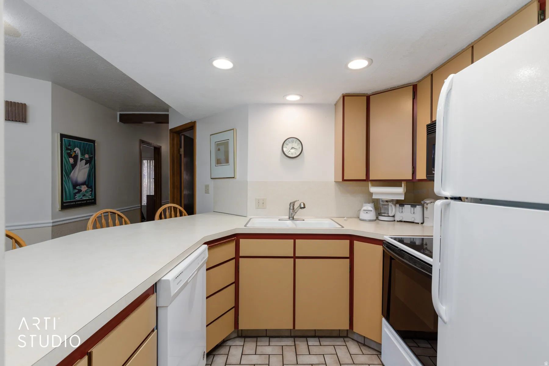Kitchen featuring a peninsula countertop with integrated sink, recessed lighting, and tile flooring