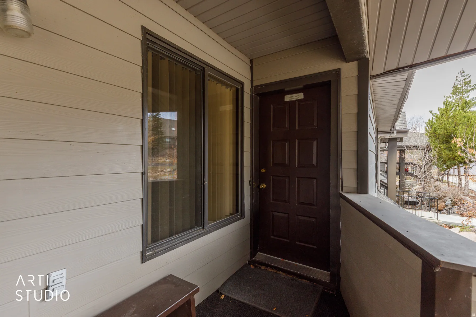 Entryway featuring a paneled door, horizontal siding, and an overhead lighting fixture