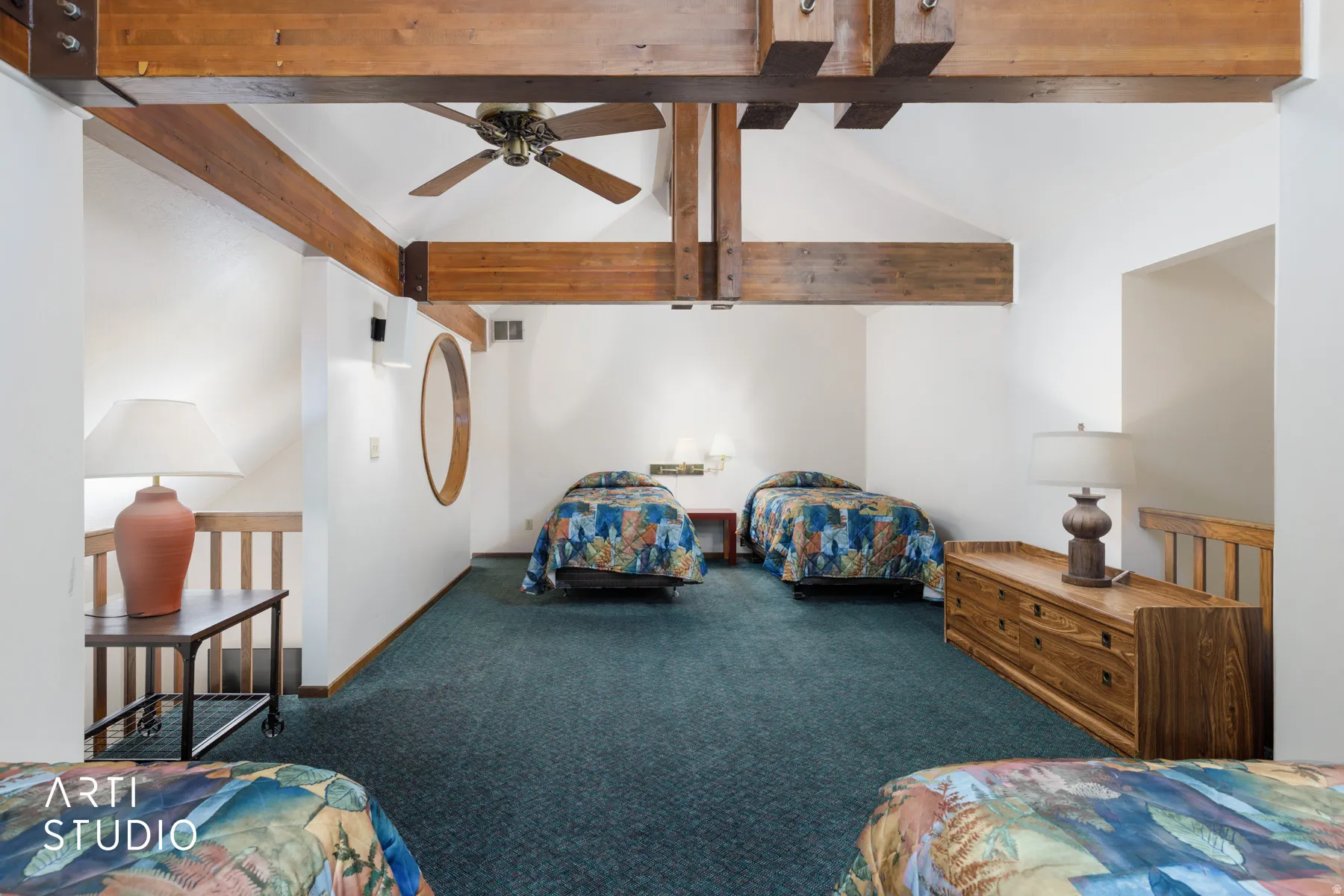 Vaulted ceiling with exposed wood beams and ceiling fan, white walls, and dark green carpeted flooring
