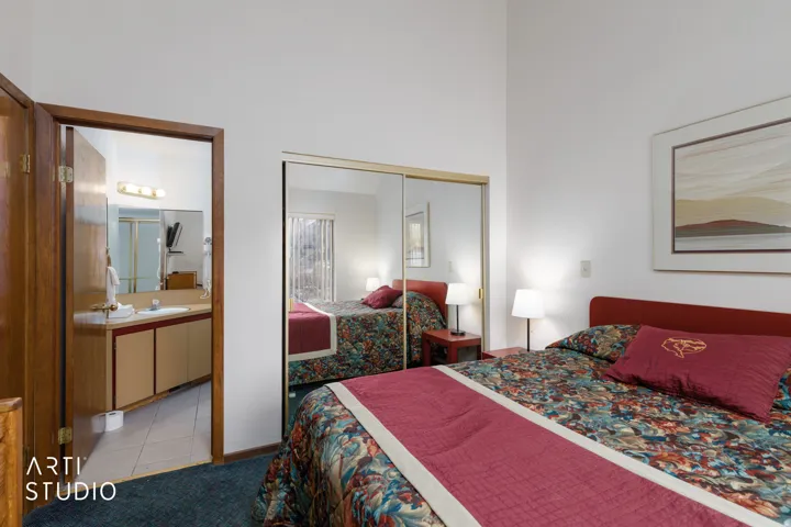 Bedroom featuring a vaulted ceiling and sliding mirrored closet doors