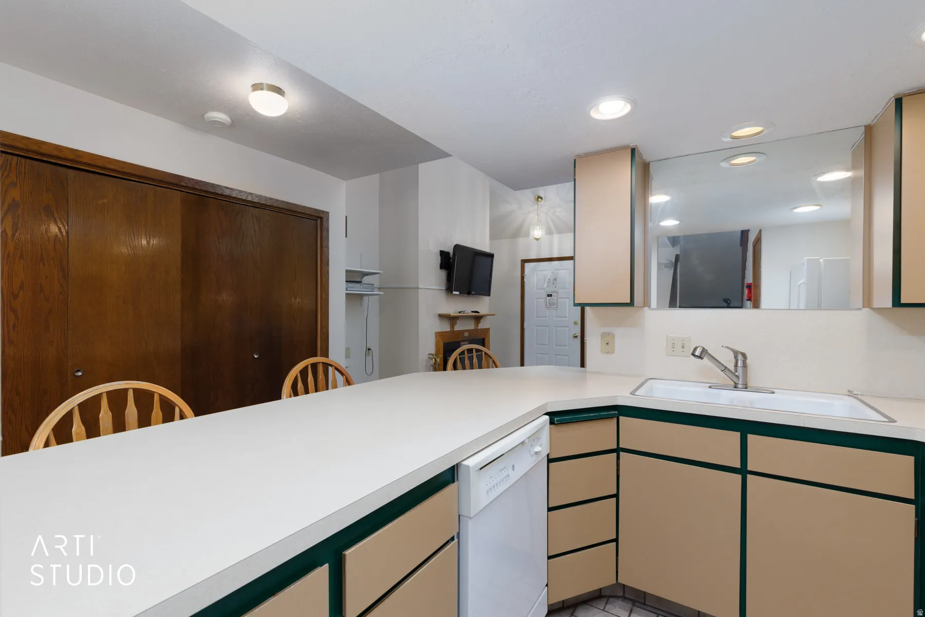 Kitchen area featuring a light-toned countertop, integrated sink, and dishwasher