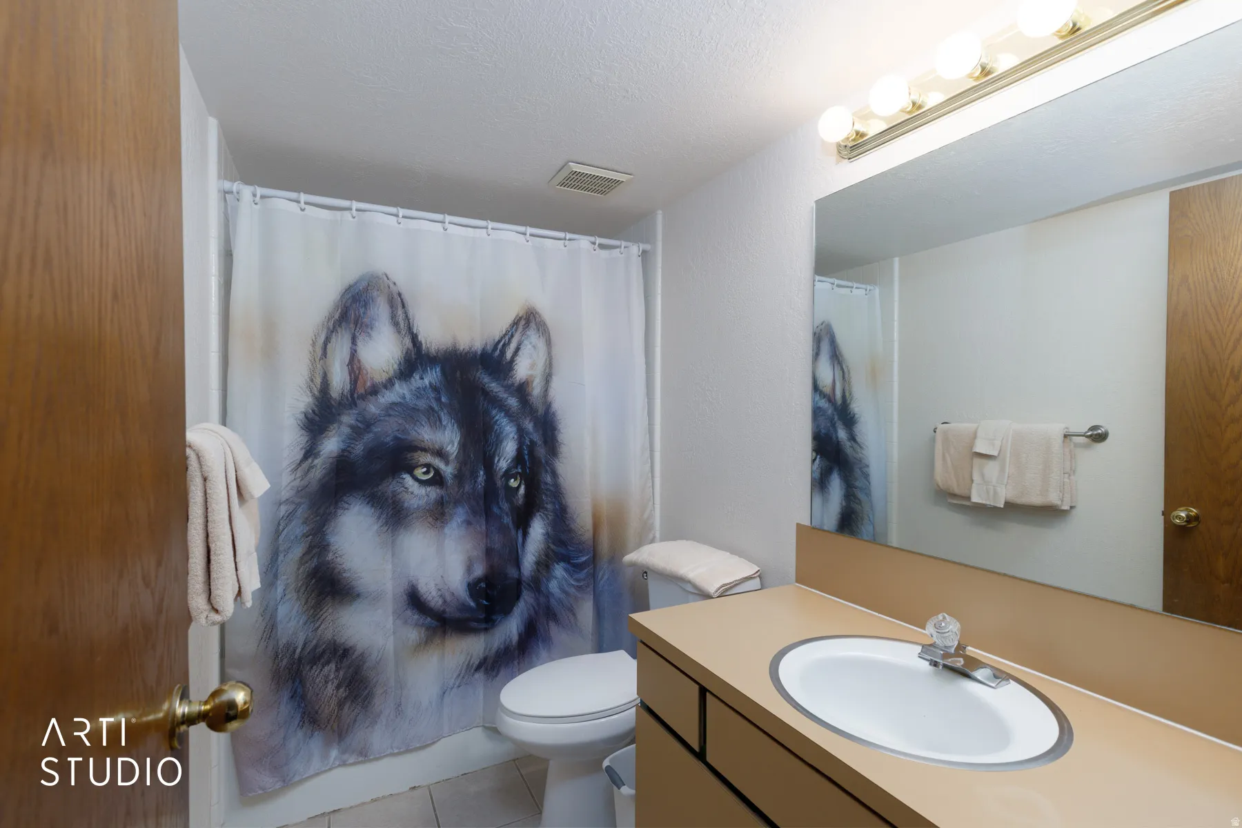 Bathroom featuring a built-in vanity with an integrated sink, a large wall-mounted mirror, and overhead strip lighting
