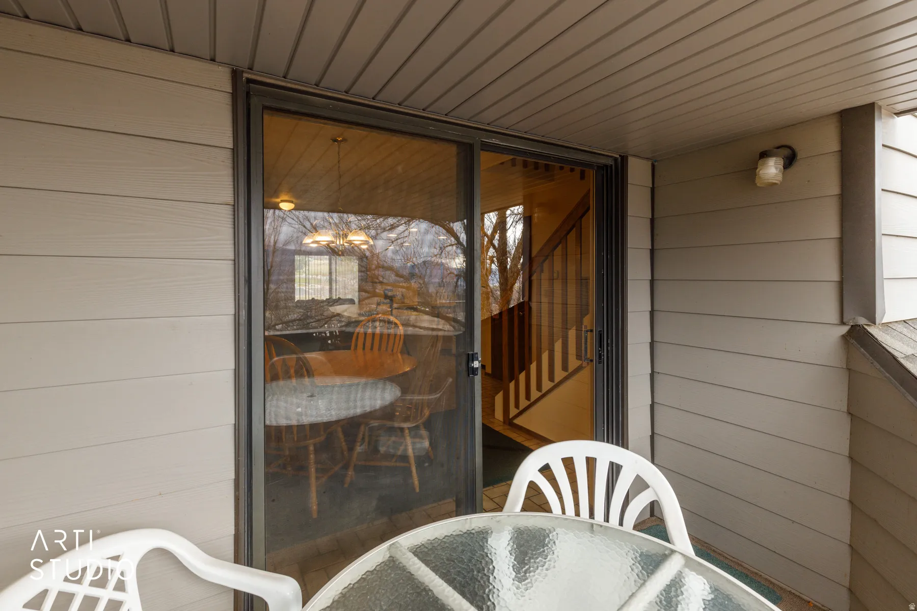 Outdoor patio area featuring horizontal siding and a sliding glass door