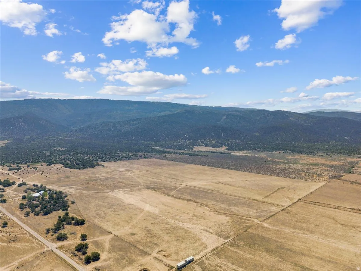 Expansive land parcel with mountainous backdrop and scattered trees