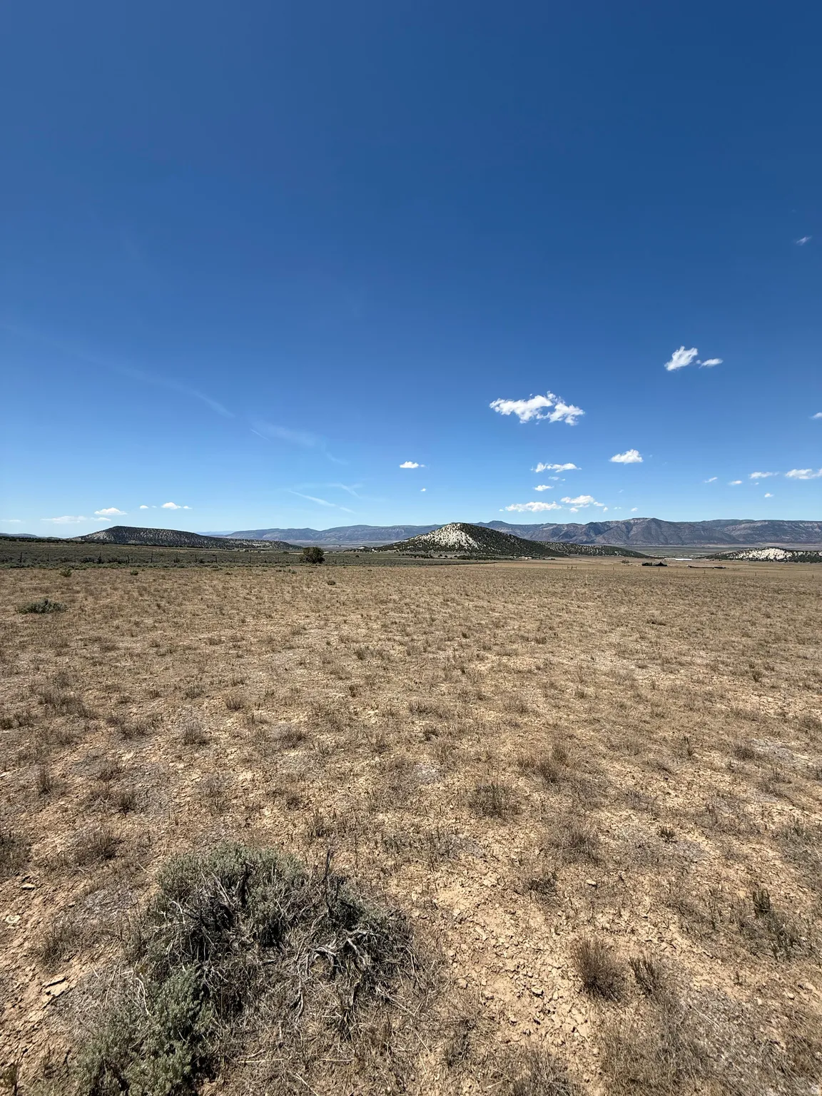 Expansive open landscape with distant hills under a clear blue sky