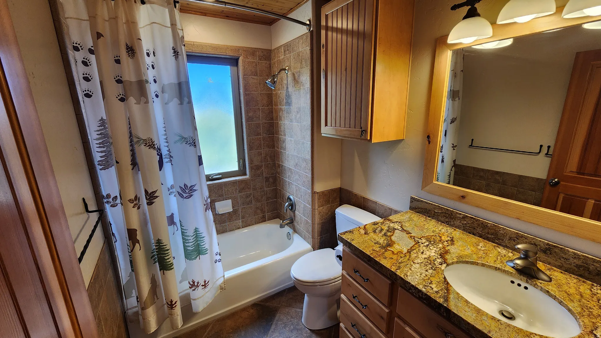 Bathroom vanity featuring a vessel sink, a granite-finish countertop, and wood-finish cabinetry