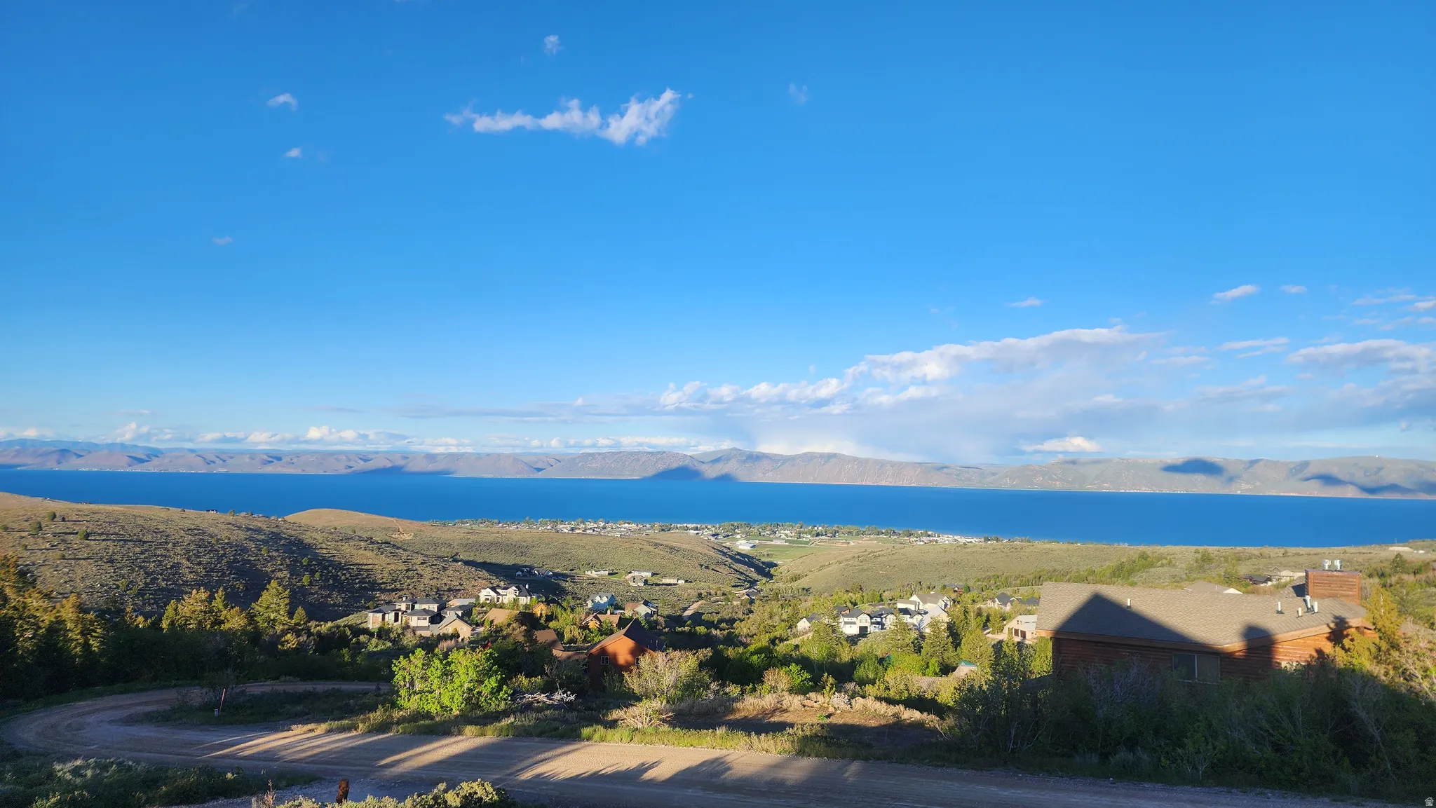 Expansive water body framed by distant mountains and a blue sky