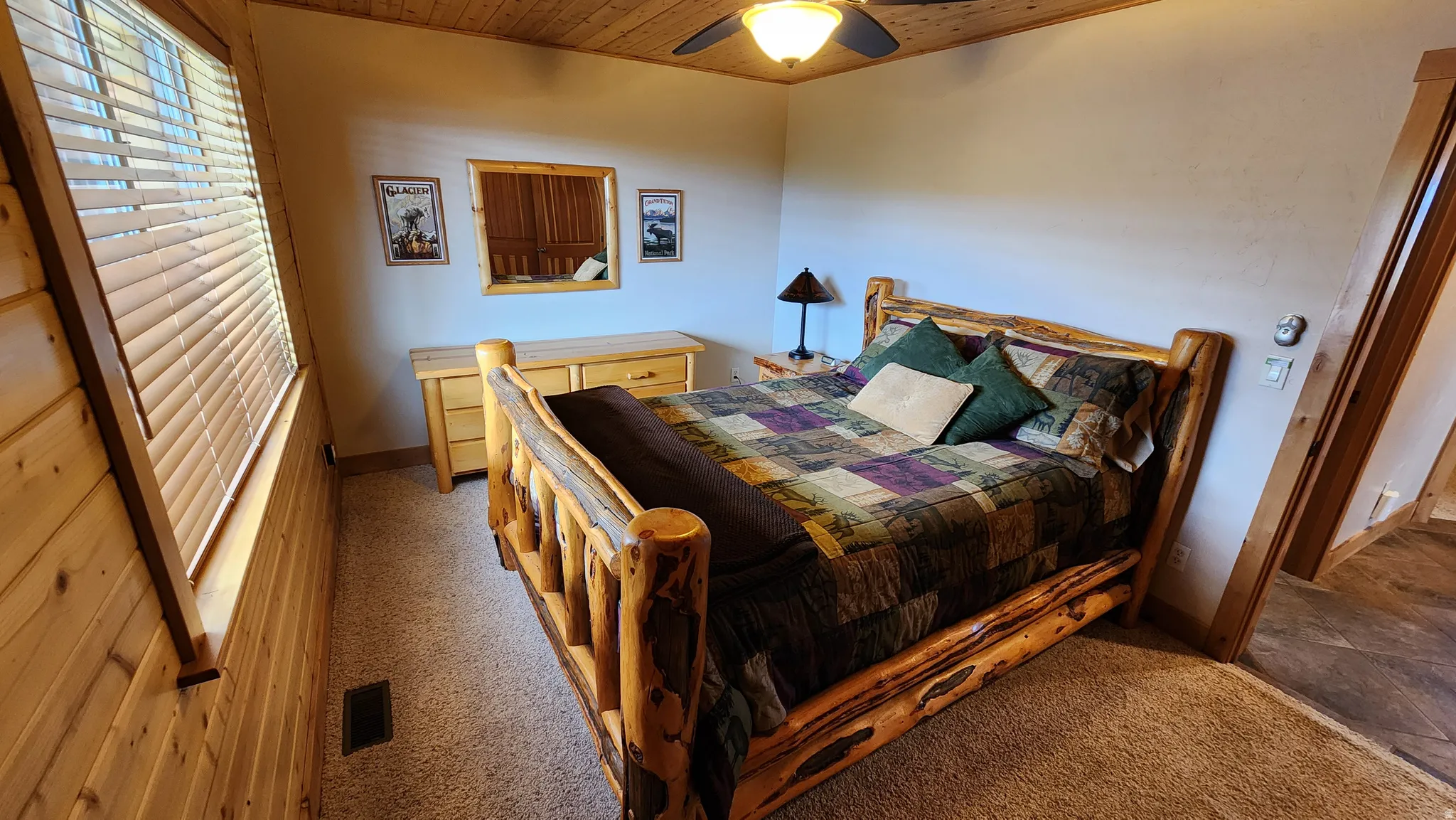 Bedroom featuring a wood-finish plank ceiling, a ceiling fan with integrated lighting, and a window with blinds