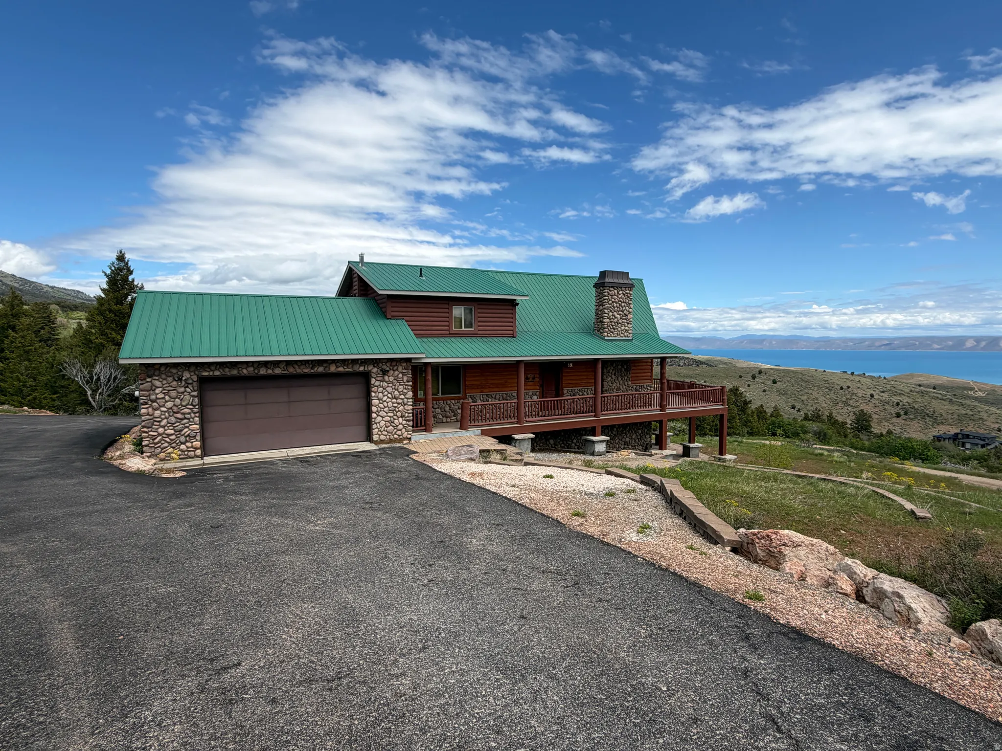 Mountain-style exterior with wood siding, stone accents, and a vibrant green metal roof
