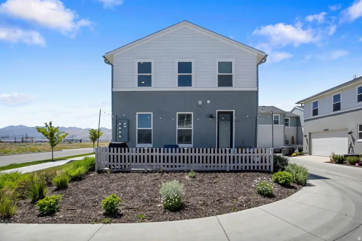 View of side of home with fenced in patio and landscaping.