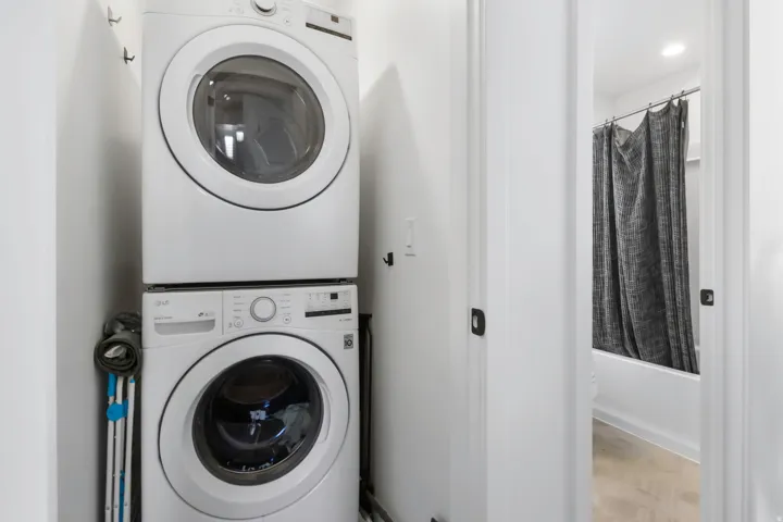 Dedicated laundry area featuring a stacked washer and dryer unit located on second floor by bedrooms