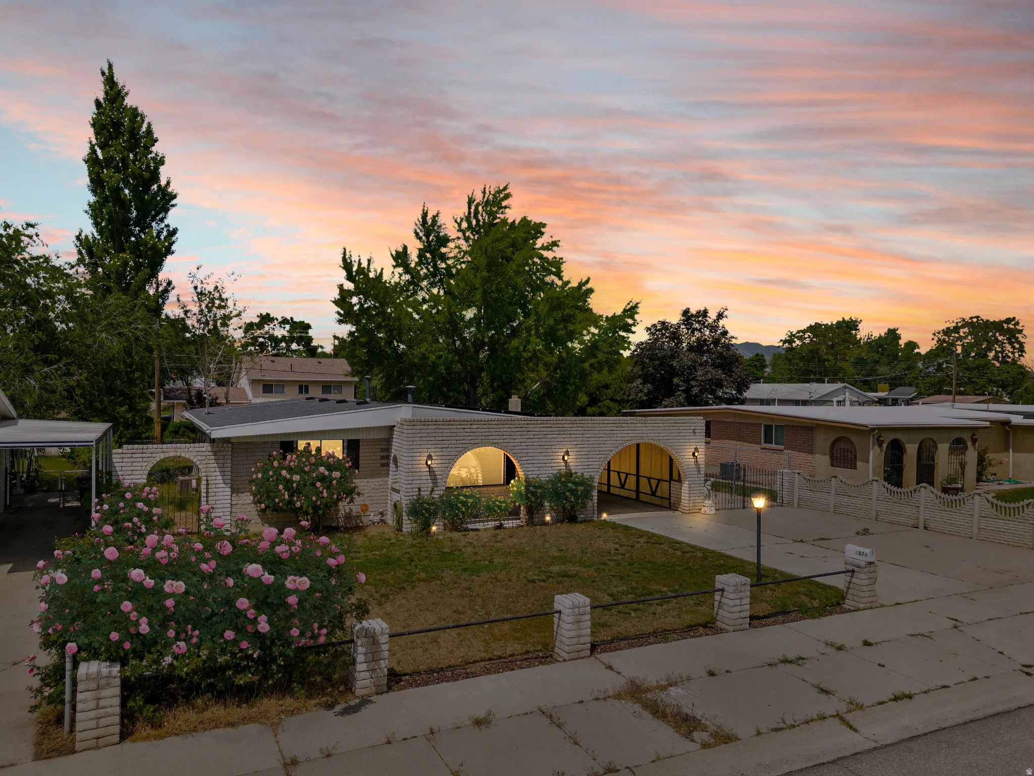 Single-story residence featuring a light brick exterior and an arched portico