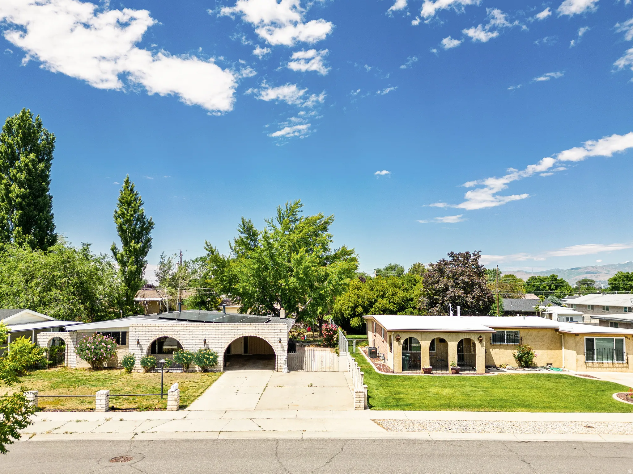 Brick exterior featuring arched carport and front entryways