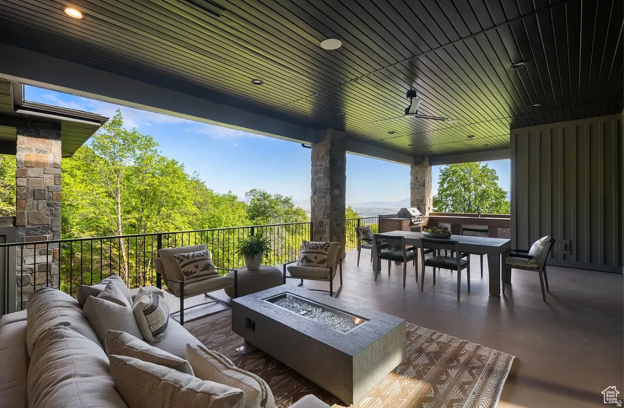 Expansive covered patio featuring a dark slatted ceiling, recessed lighting, and a ceiling fan