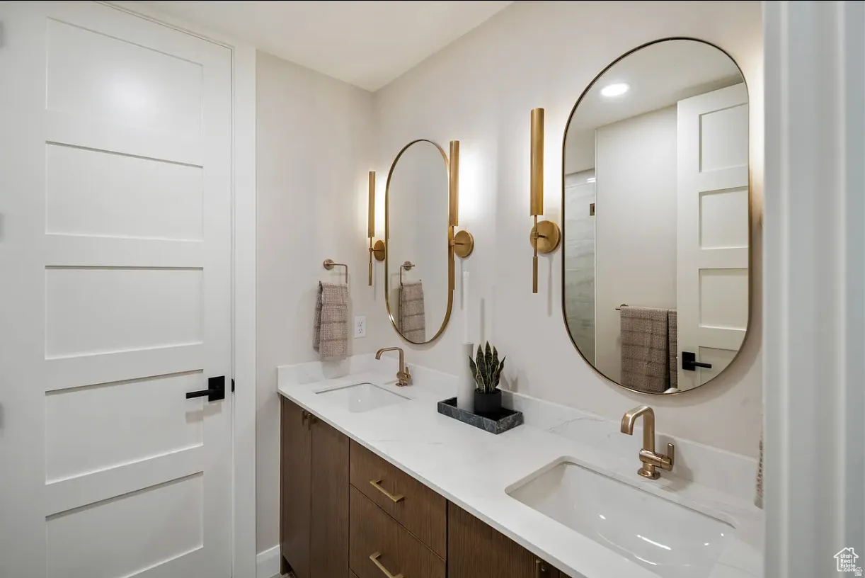 Double vanity featuring wood-finish cabinetry, white countertops, and undermount sinks