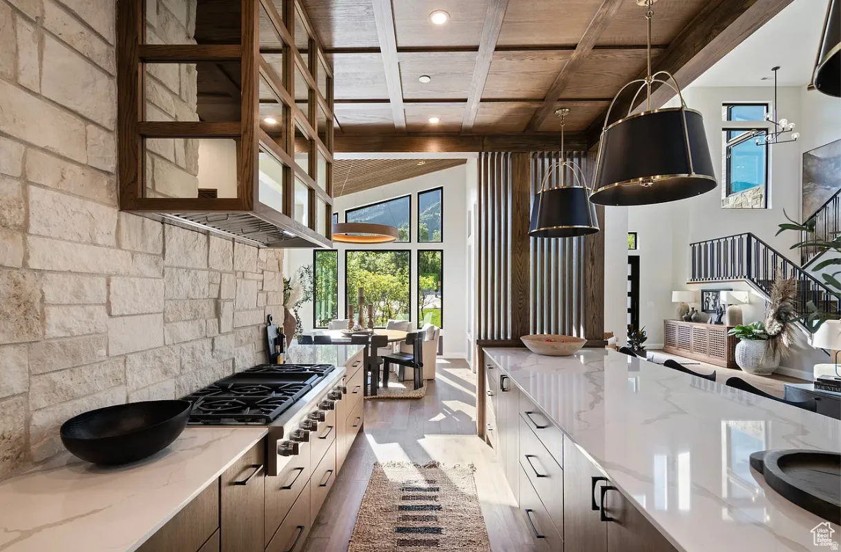 Gourmet kitchen featuring a built-in range, white stone countertops, wood-finish cabinetry, stone-clad backsplash, and a wood-slatted ceiling with recessed lighting