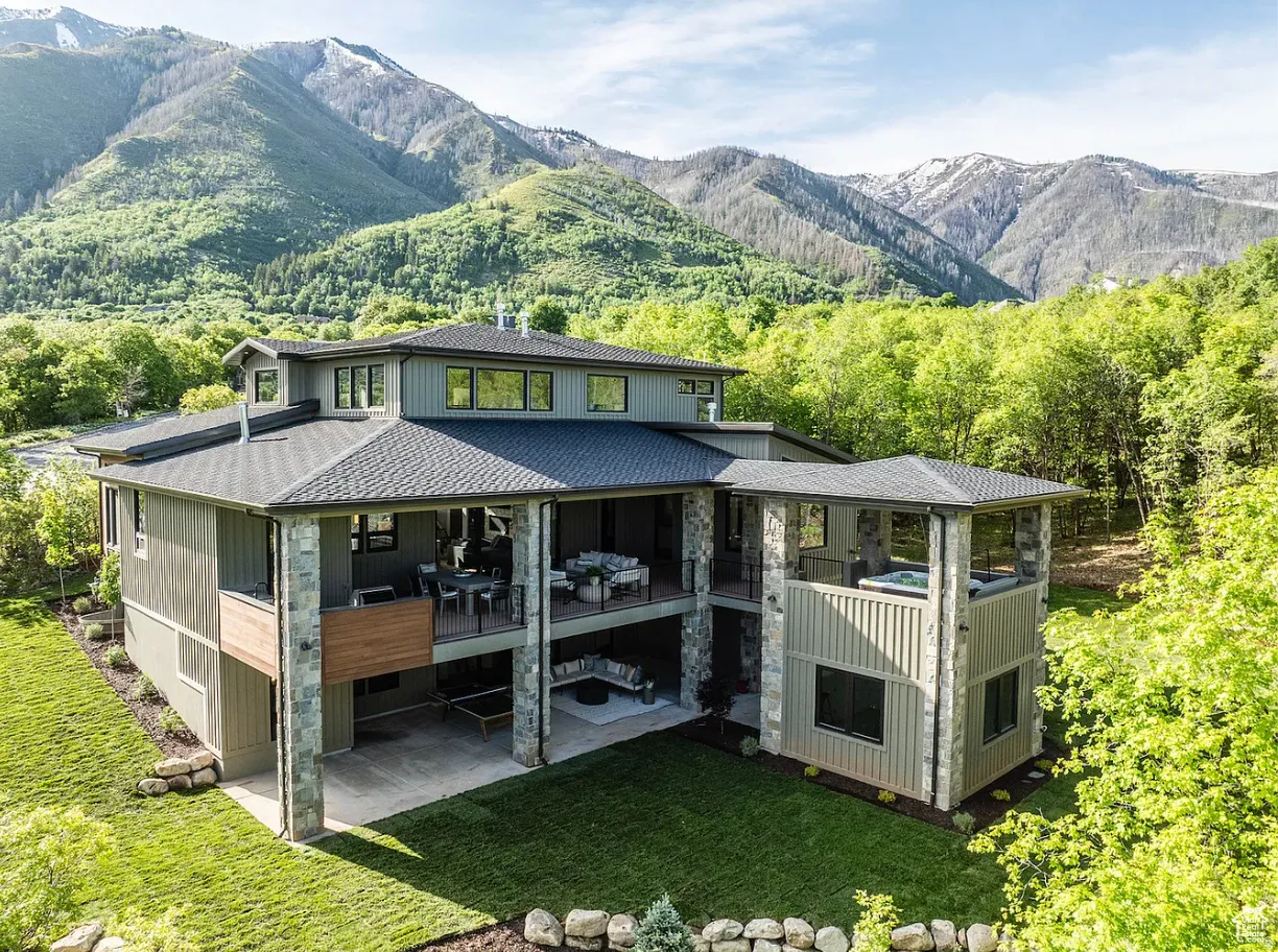 Multi-level residence featuring a dark gray roof, board and batten siding, and stone accents