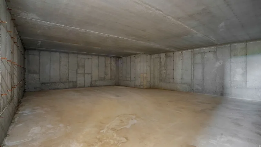 Unfinished basement featuring concrete walls and flooring