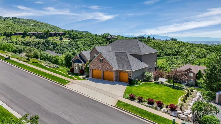 Expansive residential property featuring a multi-level design, brick and stucco exterior, and a three-car garage