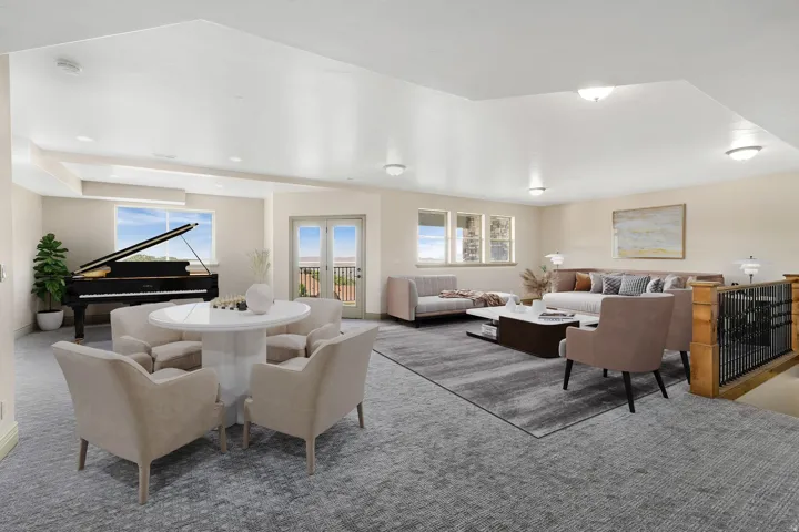 Spacious multi-zone room featuring recessed lighting, a built-in wooden baluster with metal spindles, multiple windows, and exterior French doors