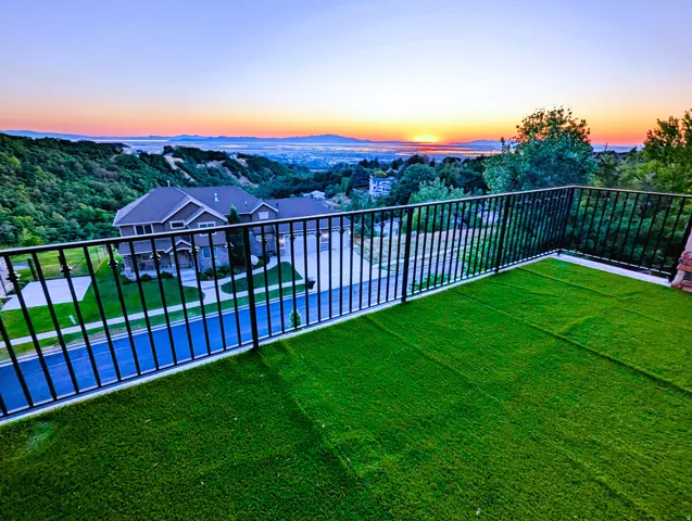 Upper-level balcony featuring artificial turf flooring and black metal railings