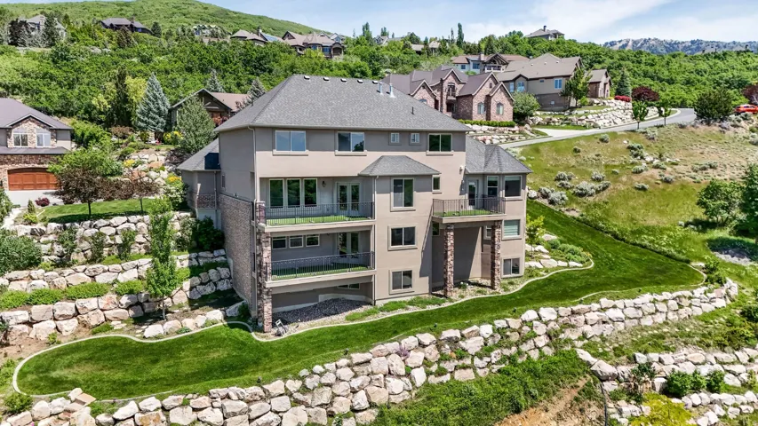 Terraced hillside property featuring extensive rock retaining walls and manicured green spaces