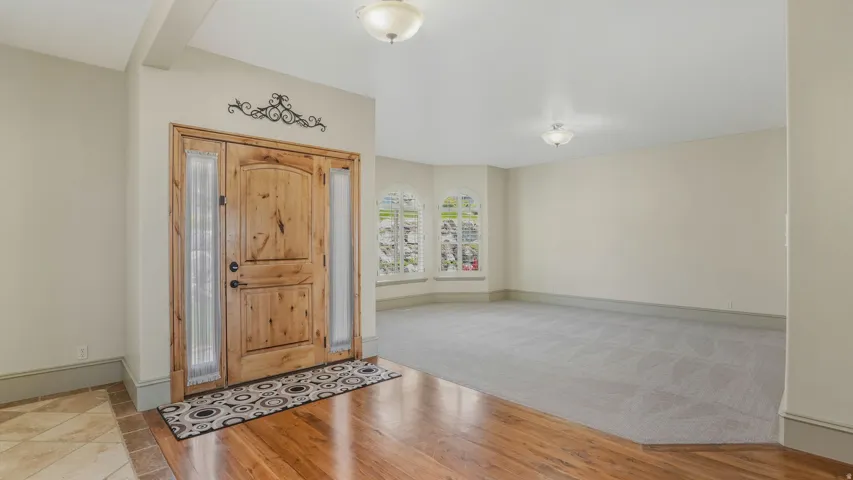 Grand entryway featuring a solid wood door with decorative sidelights