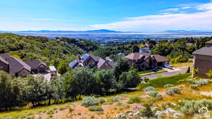 Expansive hillside setting featuring multiple residences with distant city and mountain backdrops