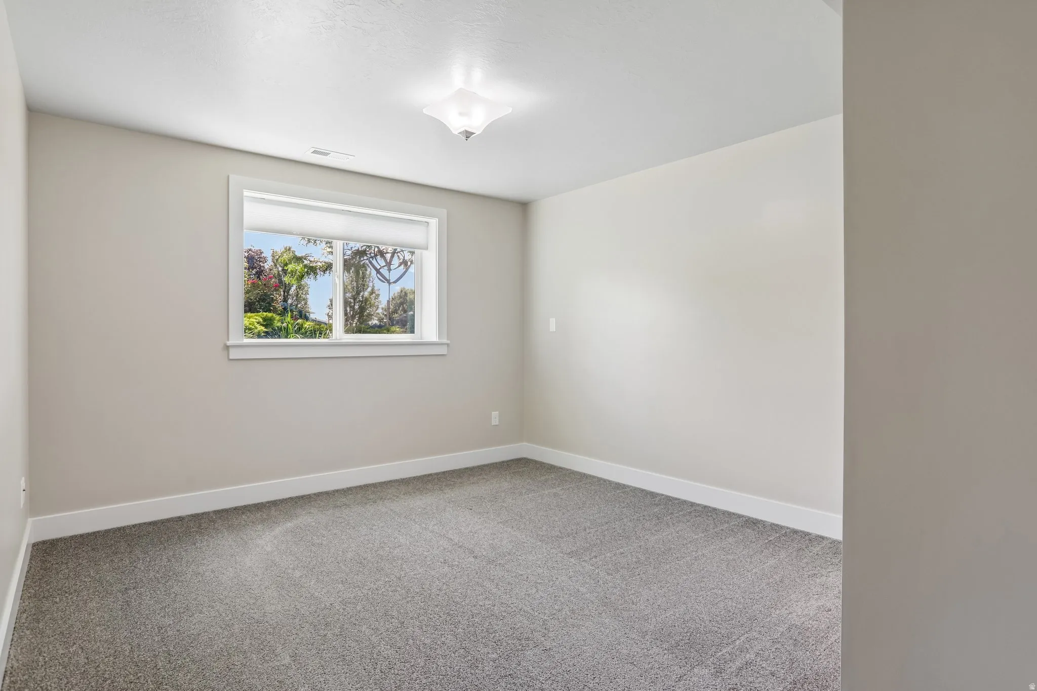 Bedroom 3 - Neutral tone wall paint with white trim, light brown carpet flooring, and a single window with picture frame molding and a new cellular shade
