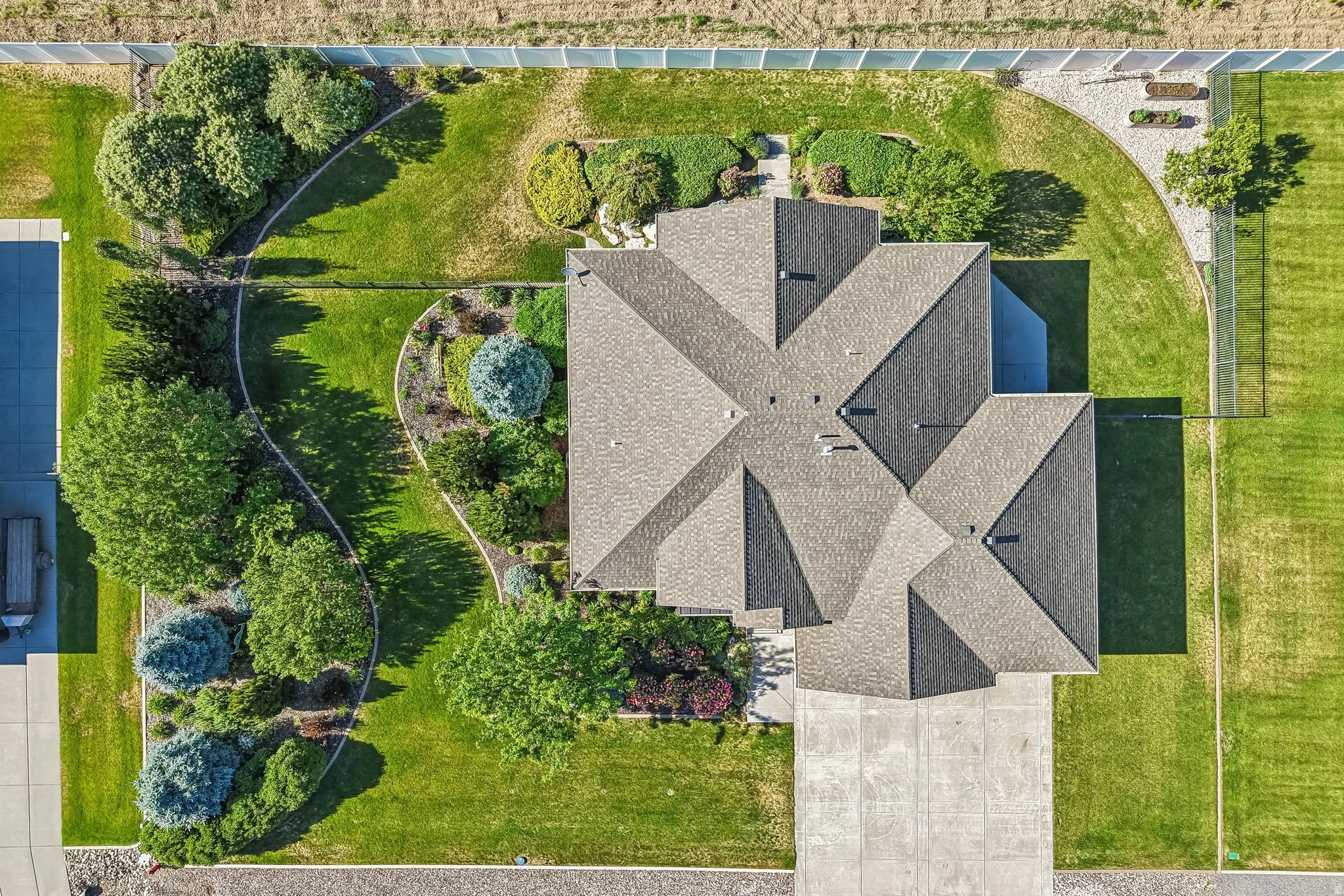 Aerial view highlighting the property's roofline and expansive green spaces