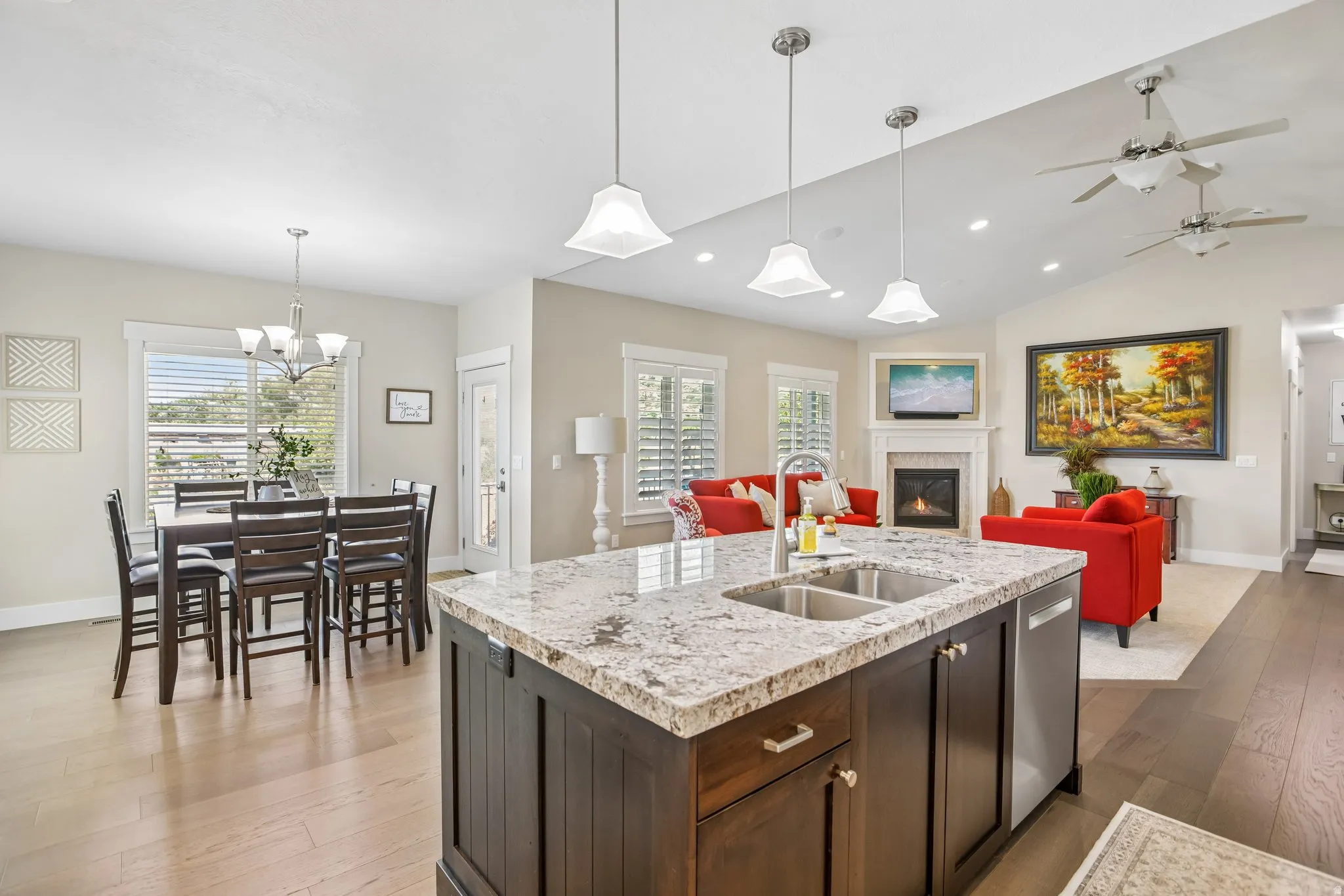 Kitchen island featuring large granite countertop, undermount double basin sink, and Bosh stainless steel dishwasher, dinning area with walk out to back patio