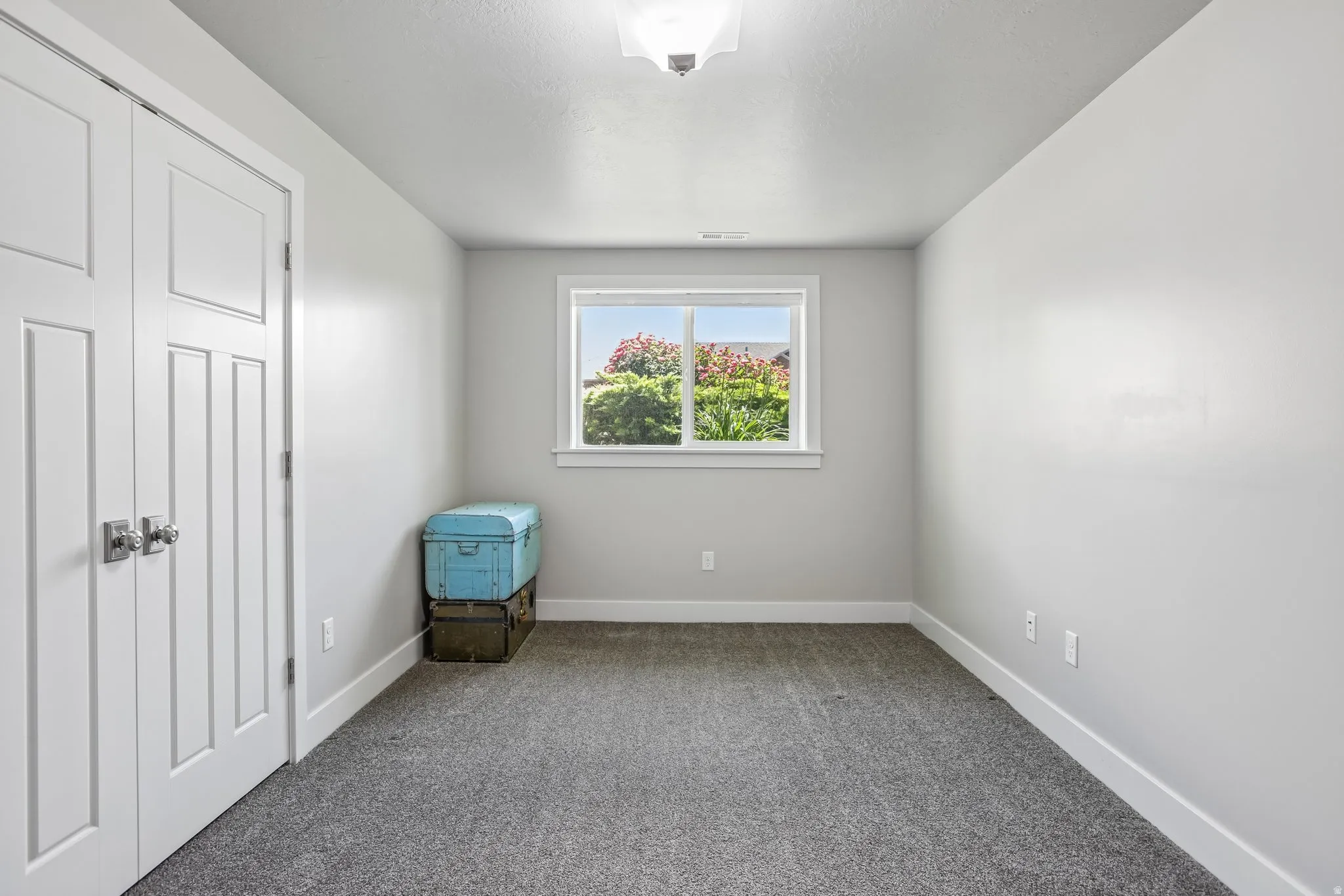 Bedroom 4 - Carpeted room with a double-pane window with picture frame moldings and a built-in closet featuring bi-fold doors