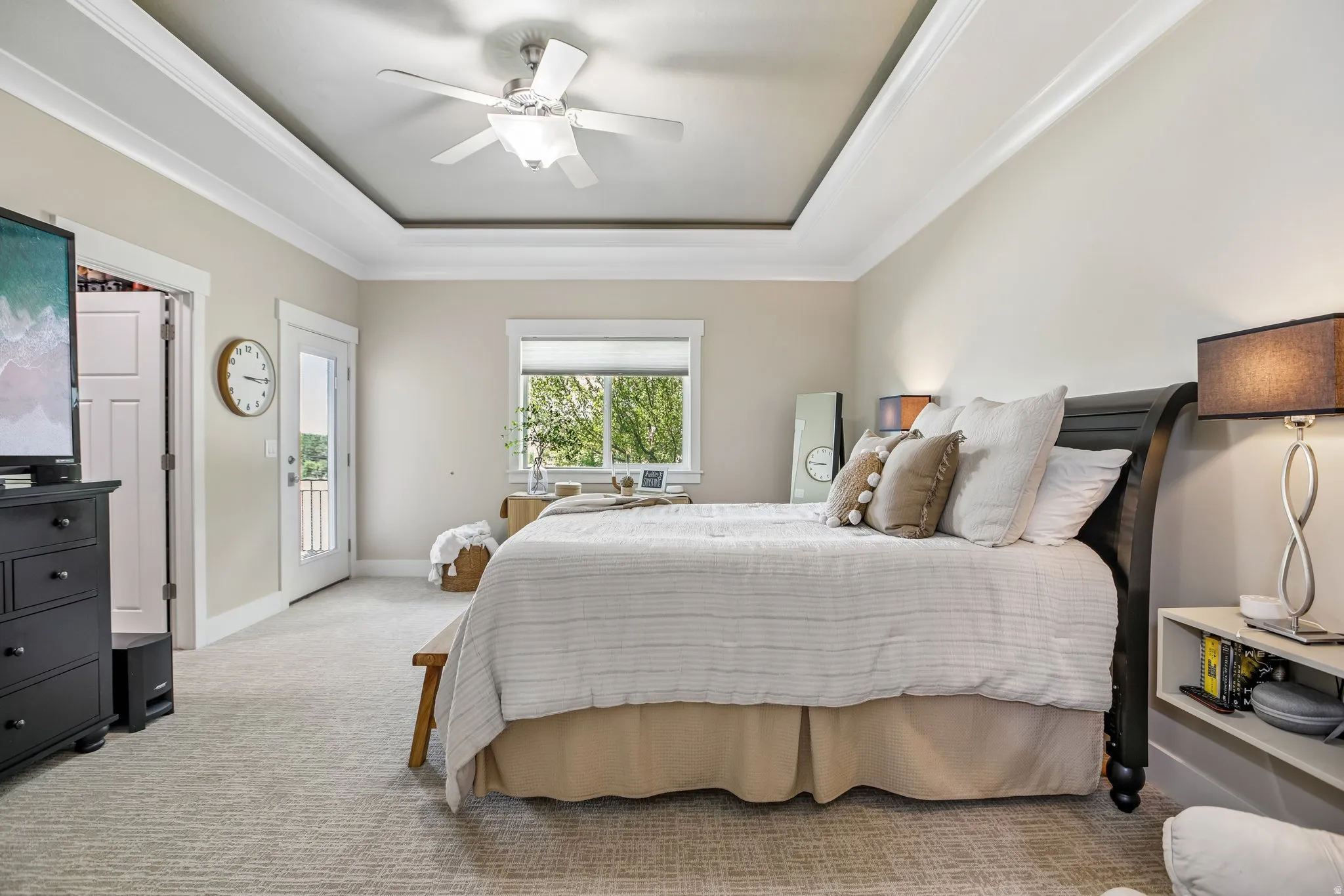 Tray ceiling with crown molding, ceiling fan, walk in closet with organizer, new carpet flooring,  new pain, transom window, and exterior door with atrium glass panel leading to patio and built in hot-tub