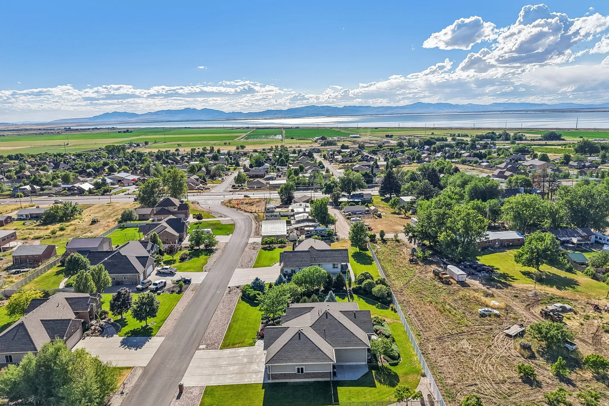 Expansive landscape featuring distant mountains, lake view, and surrounding green fields and peach orchards
