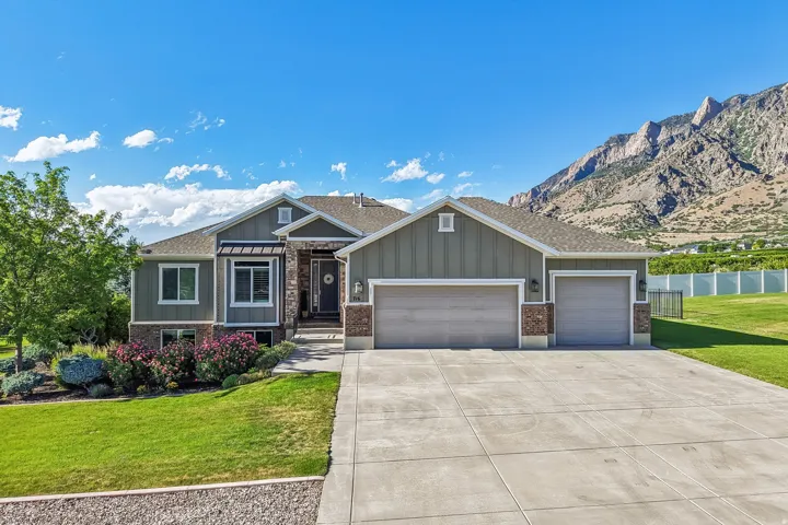 Modern ranch-style residence featuring vertical cement board exterior, brick and stone accents with welcoming covered front porch