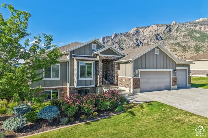 Contemporary exterior featuring board and batten siding, stone facade, and a multi-car garage