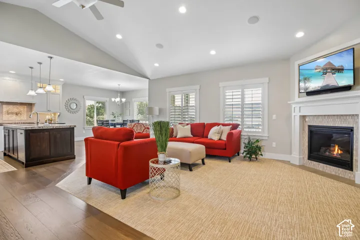 Spacious open-concept living area featuring a vaulted ceiling and recessed lighting, plantation shutters and gas fireplace