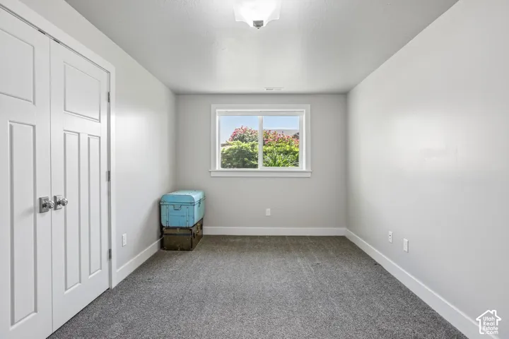 Bedroom 4 - Carpeted room with a double-pane window with picture frame moldings and a built-in closet featuring bi-fold doors