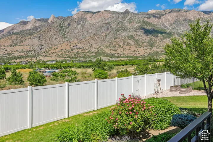 Expansive grounds featuring, mature trees, manicured lawn, and planted garden beds, all set against a stunning mountain views
