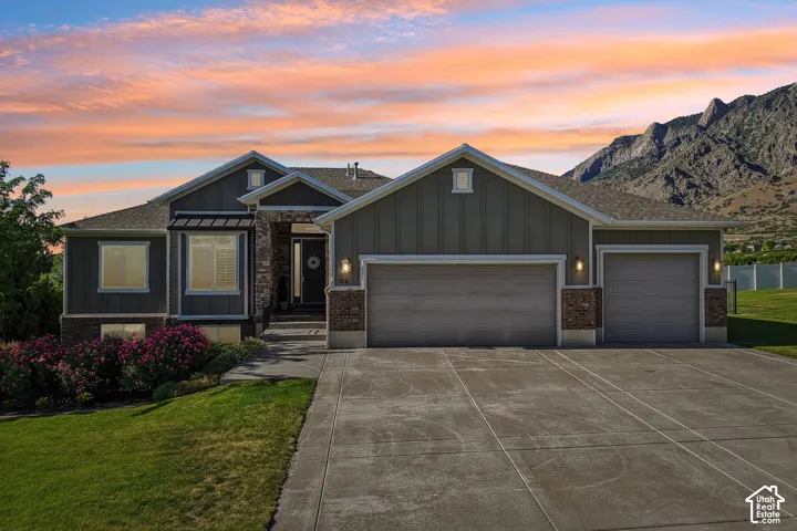 Stone and siding exterior with a multi-car driveway and an attached two-car garage