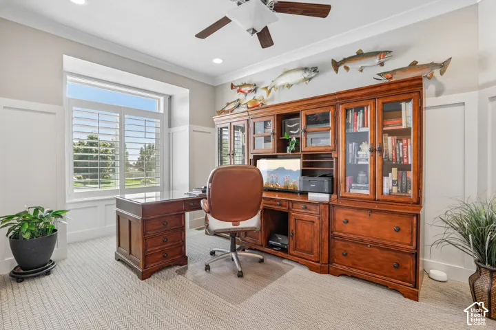 Spacious room featuring a large window with plantation shutters, custom built-in wood cabinetry, recessed lighting, a ceiling fan, and light-toned carpet flooring