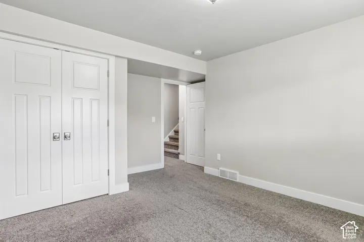 Bedroom 3 - Carpeted room featuring white bi-fold closet doors with square silver hardware, crisp white baseboards, and new cellular shade and fresh paint