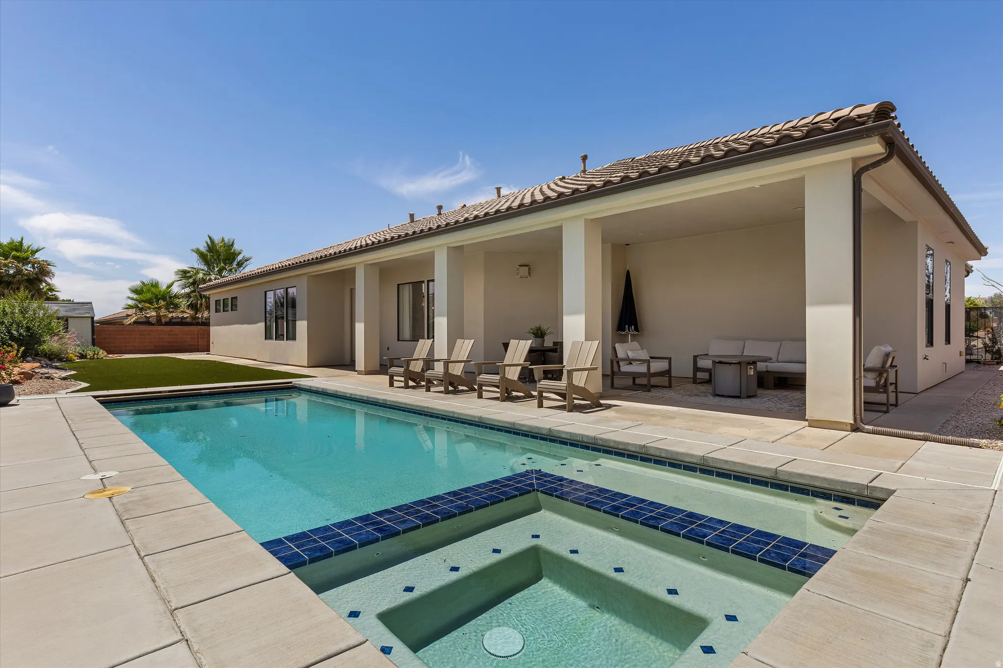 Backyard oasis featuring a rectangular swimming pool with integrated spa and blue tile detailing