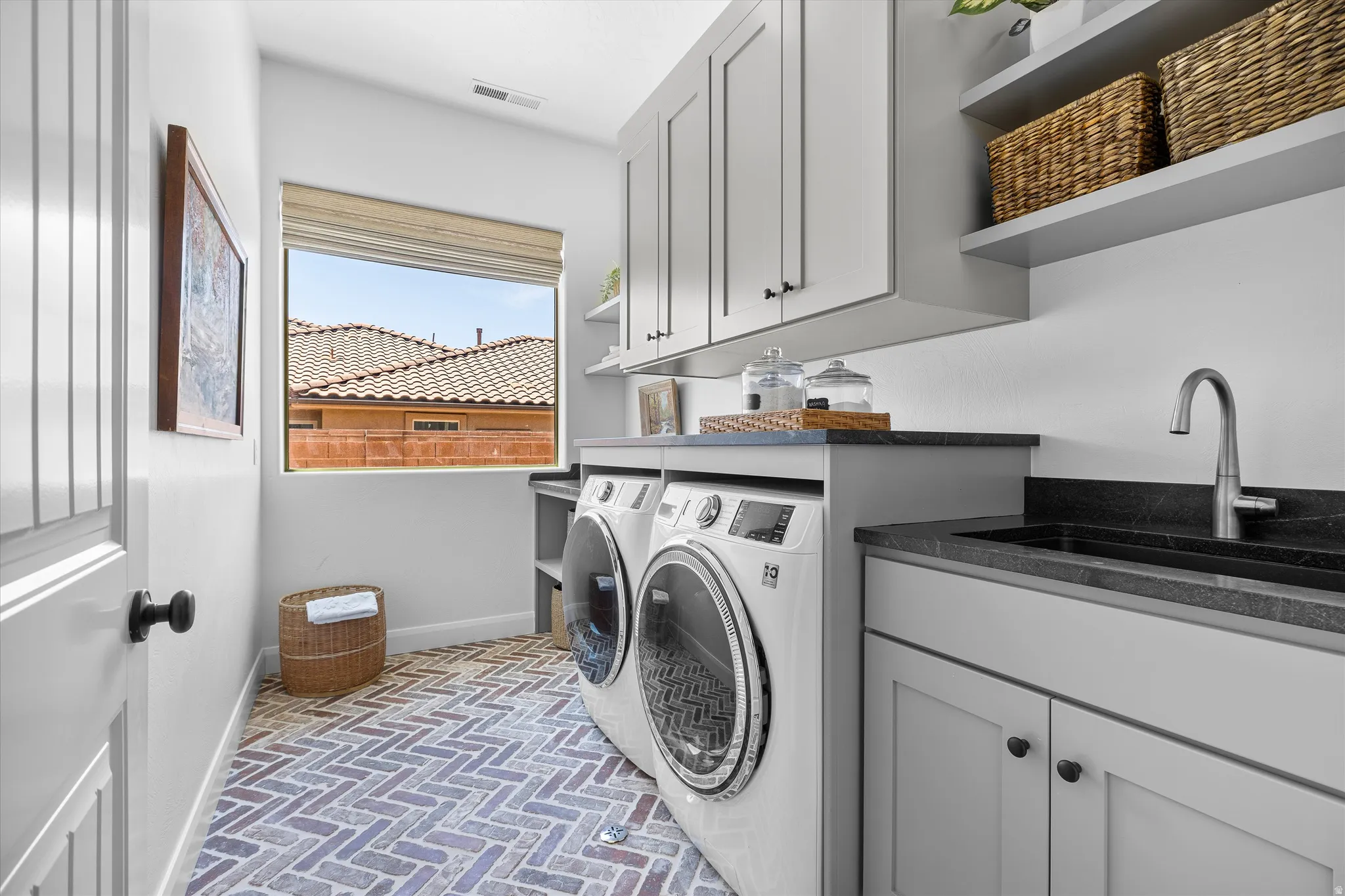 Laundry room featuring herringbone brick-style flooring