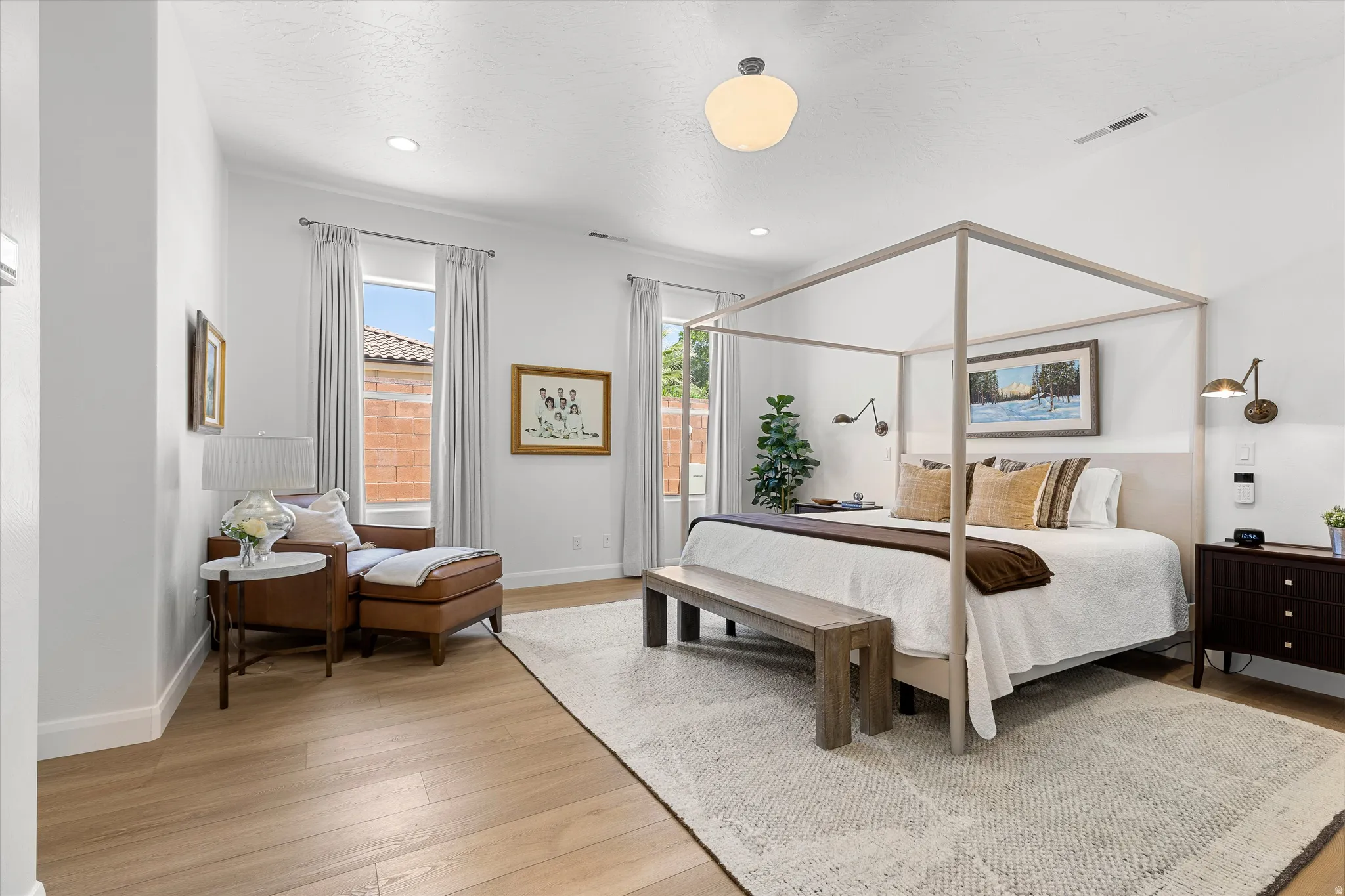 Spacious bedroom featuring light wood-finish flooring and recessed lighting