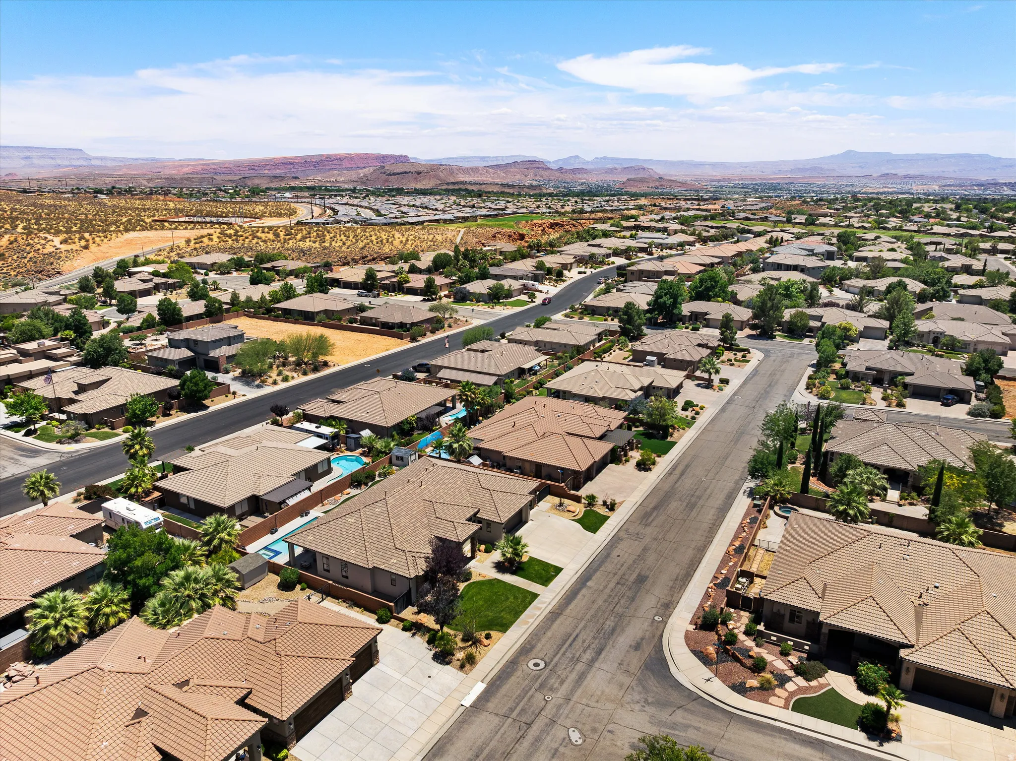 Aerial perspective showcasing a residential community with numerous single-story homes featuring tile roofs