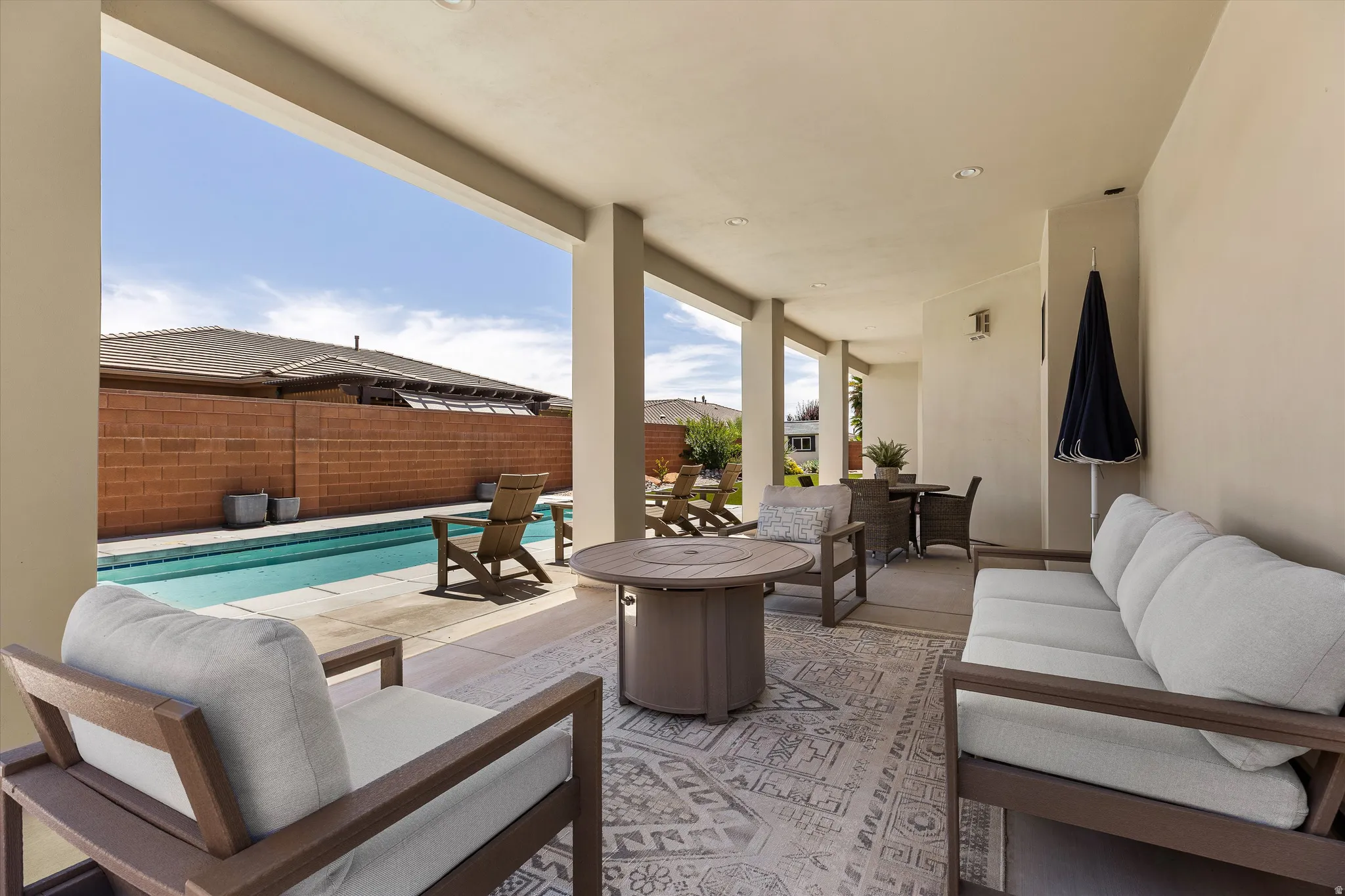 Covered patio featuring an outdoor area rug, recessed lighting, and a solid privacy wall